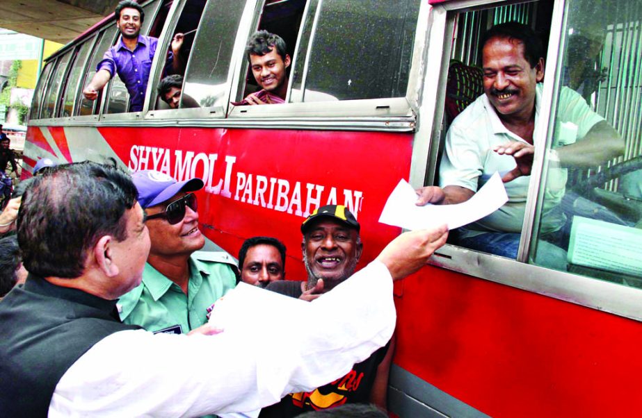 Shipping Minister Shajahan Khan distributing leaflets among the people with a view to raising awareness against launch and road mishaps. The snap was taken from Jatrabari area in the city on Tuesday.