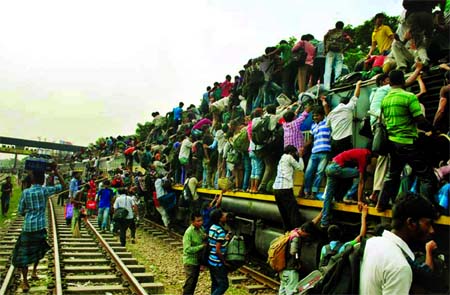 DESPERATE BID: Braving the untold sufferings, Eid goers trying to find a space on roof-top of a train. This photo was taken from Tongi Railway Station on Saturday.