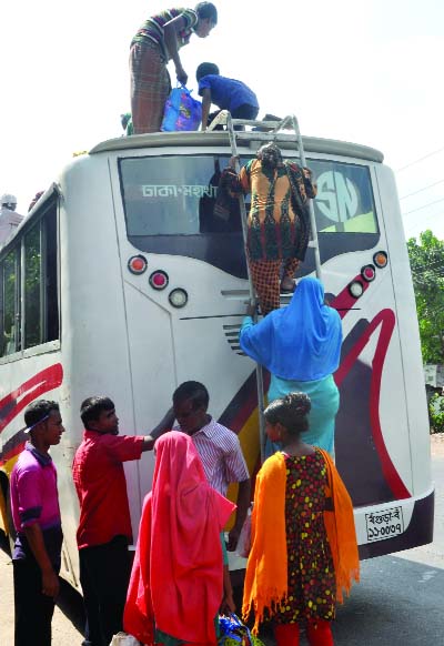 BOGRA: Women are climbing the rooftop of a bus at Bogra Highway to come to Dhaka on Friday.