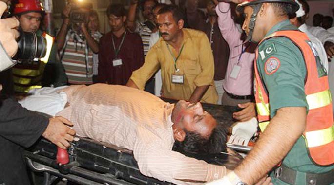 Pakistani rescue workers rush an injured person to a local hospital in Multan, Pakistan.