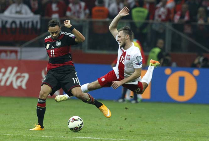 Germany's Karim Bellarabi (left) and Poland's Maciej Rybus challenge for the ball during a Euro 2016 group D qualifying soccer match between Poland and Germany in Warsaw, Poland on Saturday.