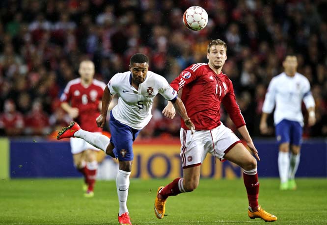 Denmark's Nicklas Bendtner and Portugal's Eliseu challenge for the ball during a Euro 2016 group I qualifying soccer match between Denmark and Portugal in Copenhagen, Denmark on Tuesday.