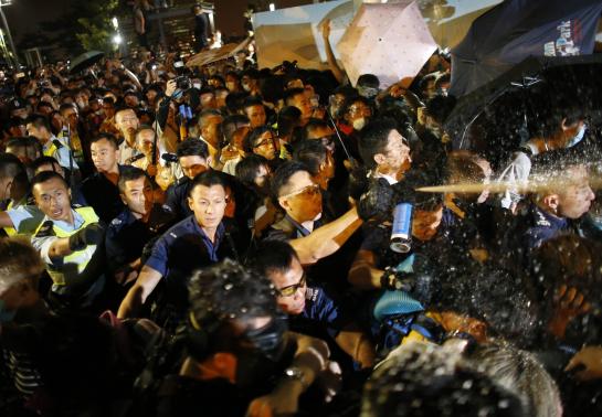 Police use pepper spray as they clash with pro-democracy protesters at an area near the government headquarters building in Hong Kong early October 16, 2014.