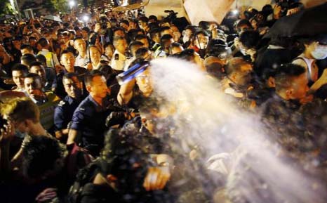 Police use pepper spray as they clash with pro-democracy protesters at an area near the government headquarters building in Hong Kong .