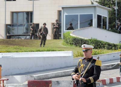 Members of the Republican Guard, background, stand guard outside the President's headquarters in the Algerian capital, Algiers, as police forces stage a protest next to the building on Thursday