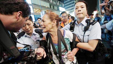 Police officers detaining Getty Images photographer Paula Bronstein during a confrontation between police and pro-democracy protesters at Mongkok shopping district in Hong Kong.