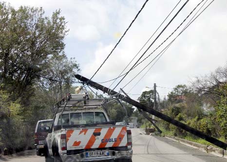 Motorists drive past damaged utiliy poles in the aftermath of the hurricane Gonzola on the French Caribbean island of Saint Martin.