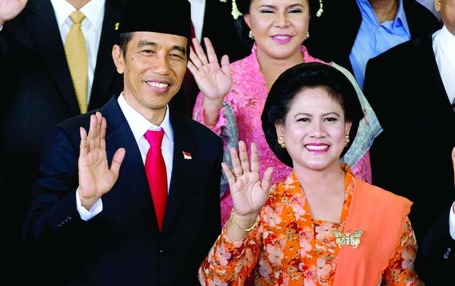 Indonesia's seventh President Joko Widodo, left, waves with his wife Iriana during a group photo following his inauguration at Parliament in Jakarta.