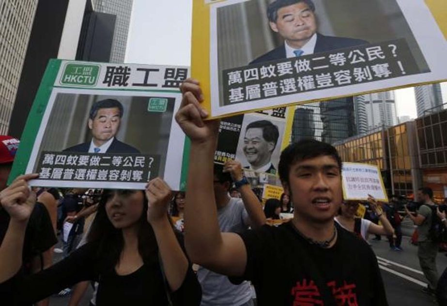 Pro-democracy protesters carrying portraits of Hong Kong Chief Executive Leung Chun-ying march to his residence in Hong Kong on Wednesday.