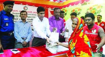 RANGPUR: Divisional Commissioner Muhammad Dilwar Bakht distributing cash money and relief goods of BDRCS among 200 flood-hit families at a ceremony arranged at Kawnia Upazila town on Tuesday.