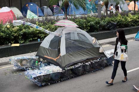 A woman walks past a tank made out of an umbrella, a tent and used plastic bottles in the Admiralty district of Hong Kong on Friday.