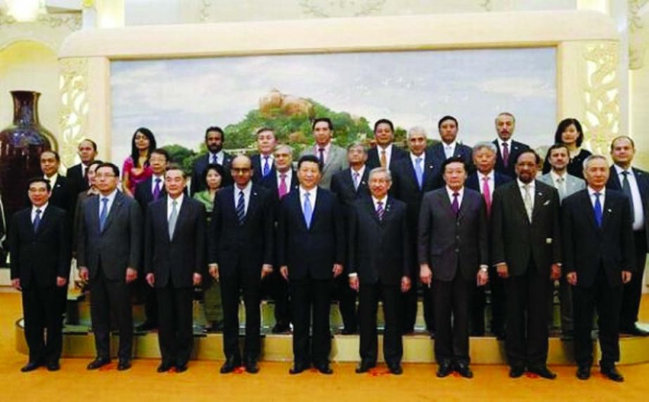 China's President Xi Jinping (C) poses for photos with the guests at the Asian Infrastructure Investment Bank launch ceremony at the Great Hall of the People in Beijing on Friday.