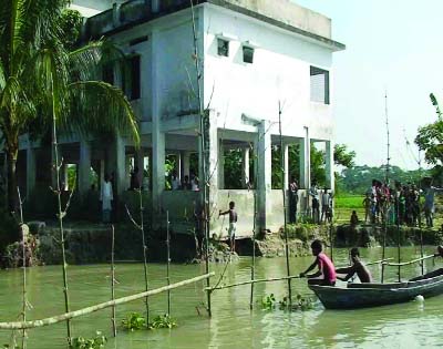 BARISAL: Sandha River erosion has threatened Khodabkhox Government Primary School in Banaripara Upazila and local people are trying hard to save the school . This picture was taken yesterday.