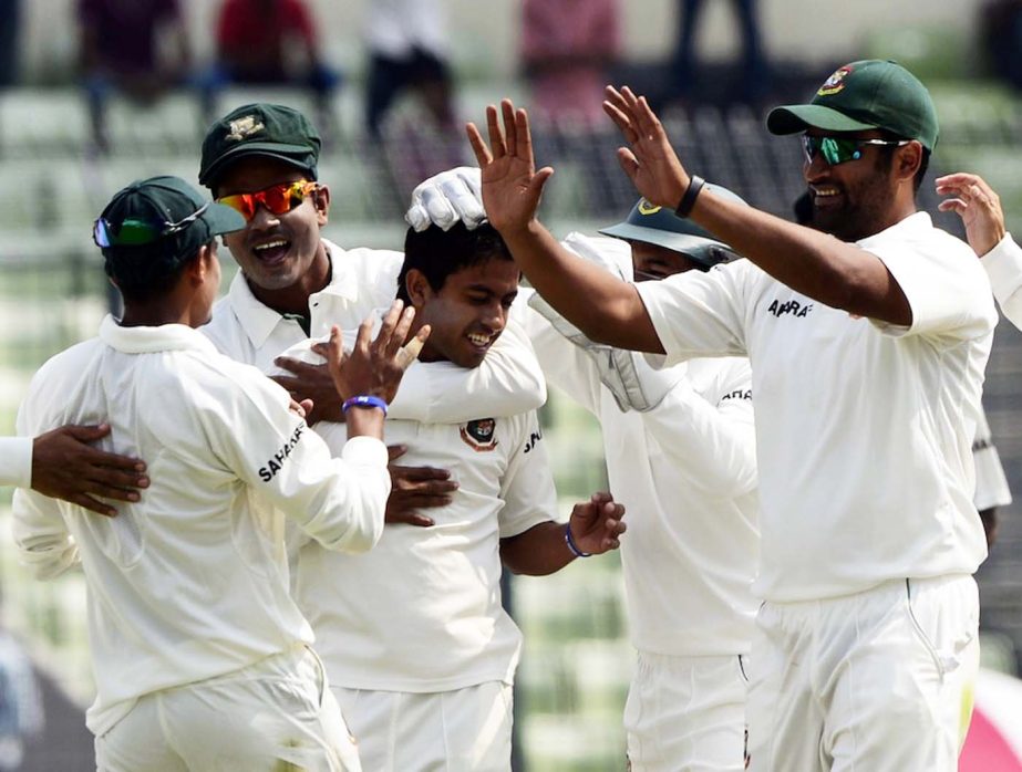 Bangladeshi cricketers congratulate teammate Jubair Hossain (3L) after the dismissal of the Zimbabwe cricket captain Brendan Taylor during the first day of the first test match between Bangladesh and Zimbabwe at the Sher-e Bangla National Stadium in Mirpu