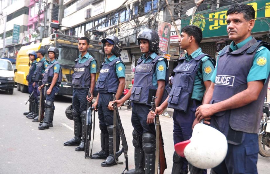 Law enforcers stand guard in front of BNP central office in the city's Nayapalton on Sunday as part of security measures during hartal hours.