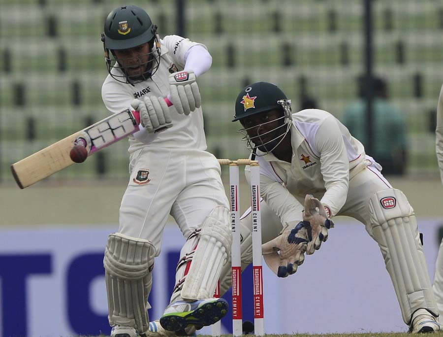 Mushfiqur Rahim (L) plays a shot as Zimbabwe wicketkeeper Regis Chakabva (R) looks on the second day of the First Test match between Bangladesh and Zimbabwe at the Sher-e Bangla National Stadium in Dhaka on Sunday.
