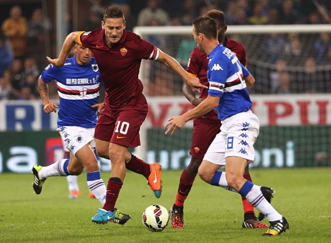 AS Roma forward Francesco Totti (left) passes the ball under pressure from Sampdoria defender Daniele Gastaldello during a Serie A soccer match between Sampdoria and AS Roma in Genoa, Italy on Saturday.
