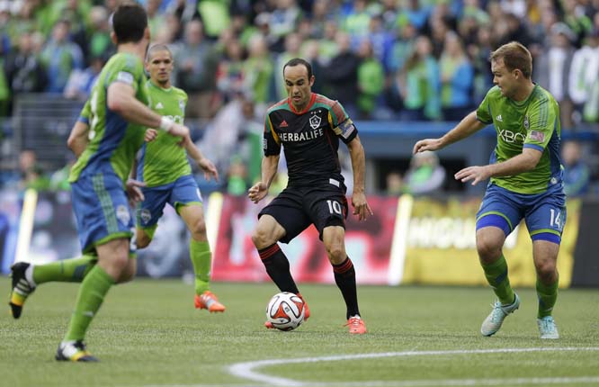 Los Angeles Galaxy midfielder Landon Donovan (center) dribbles the ball as Seattle Sounders' Chad Marshall (right) closes in during the first half of an MLS soccer match on Saturday in Seattle.
