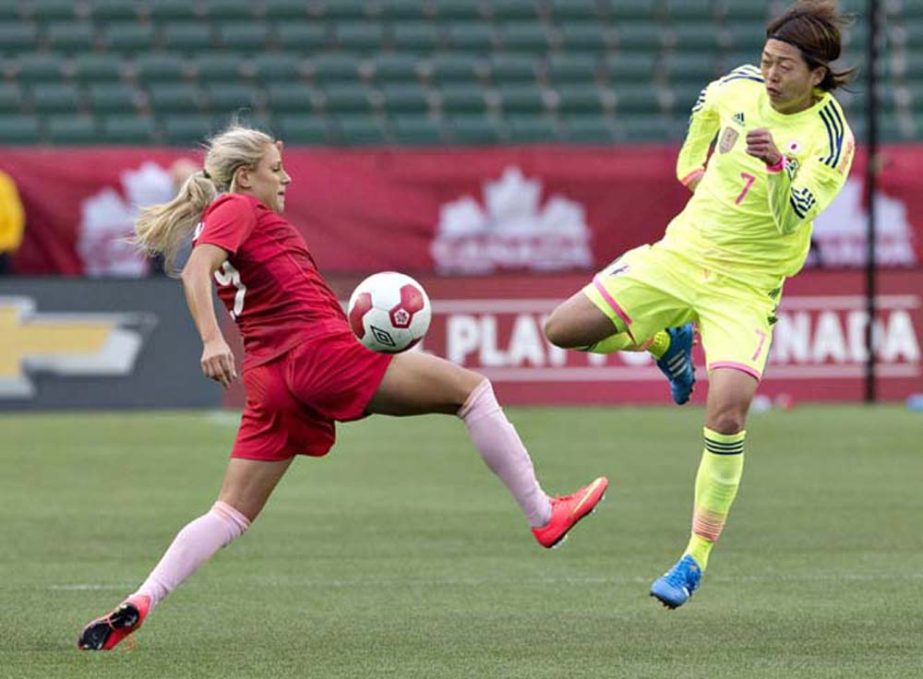 Japan's Kozue Ando (7) and Canada's Josee Belanger (9) compete for the ball during second half of an international friendly match in Edmonton, Alberta on Saturday.