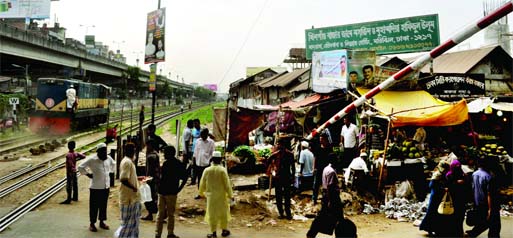 Dhaka South City Corporation runs a kitchen market adjacent to the level crossing at Khilgaon ignoring public safety and also disobeying the existing law. This photo was taken on Monday. Photo: Rafiqul Islam