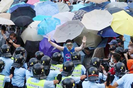 A pro-democracy demonstrator Â© gestures in front of a police line near Hong Kong government headquarters on Tuesday.