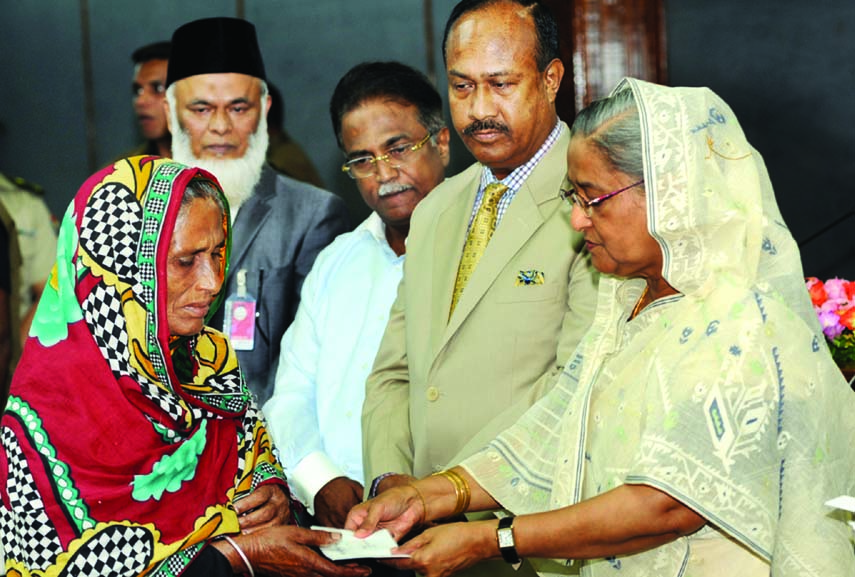 Prime Minister Sheikh Hasina handing over cheque among the families of victims of Rana Plaza collapse and Tazrin Fashion fire incident at her office on Wednesday.