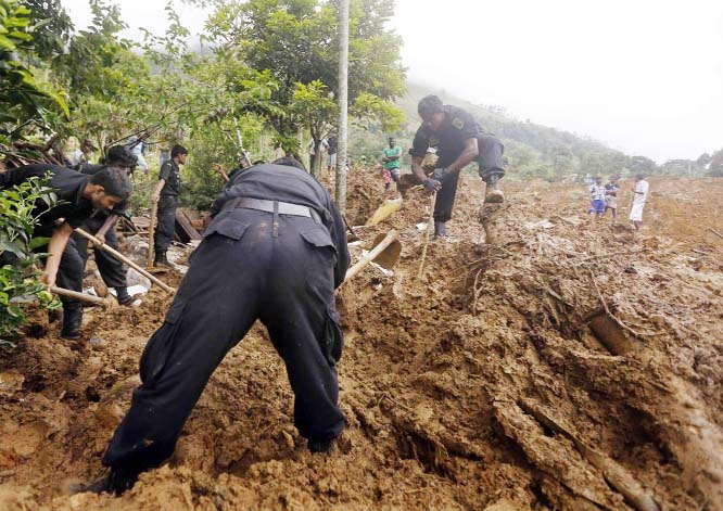 Rescue workers conduct a search at the site of a landslide at the Koslanda tea plantation near Haldummulla on Thursday.