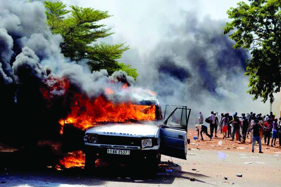 Cars and documents burn outside parliament in Ouagadougou on Thursday.