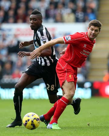 Newcastle United's Sammy Ameobi (left) vies for the ball with Liverpool's captain Steven Gerrard (right) during their English Premier League soccer match at St James' Park, Newcastle, England on Saturday.