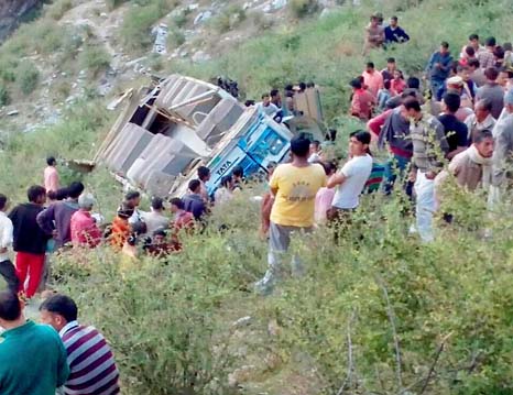 People gather near the passenger bus that rolled down into a deep gorge near Himgiri, 90km from Chamba, on Saturday.