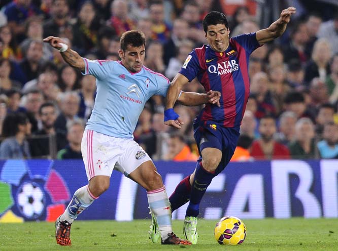 FC Barcelona's Luis Suarez, from Uruguay (right) duels for the ball against Celta de Vigo's Ruben Blanco during a Spanish La Liga soccer match at the Camp Nou stadium in Barcelona, Spain on Saturday.