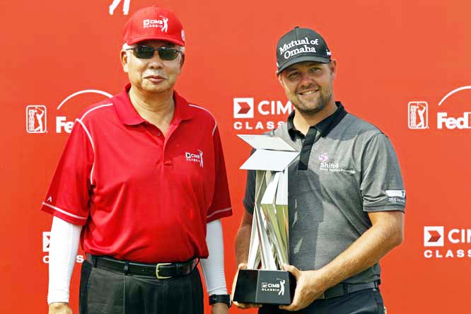 Ryan Moore (right) of the United States holds his trophy as he poses with Malaysian Prime Minister Najib Razak after winning the CIMB Classic golf tournament at the Kuala Lumpur Golf and Country Club in Kuala Lumpur, Malaysia on Sunday.