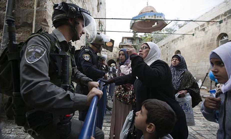 A Palestinian woman argues with an Israeli border police officer near the Lions Gate in the Old City of Jerusalem.