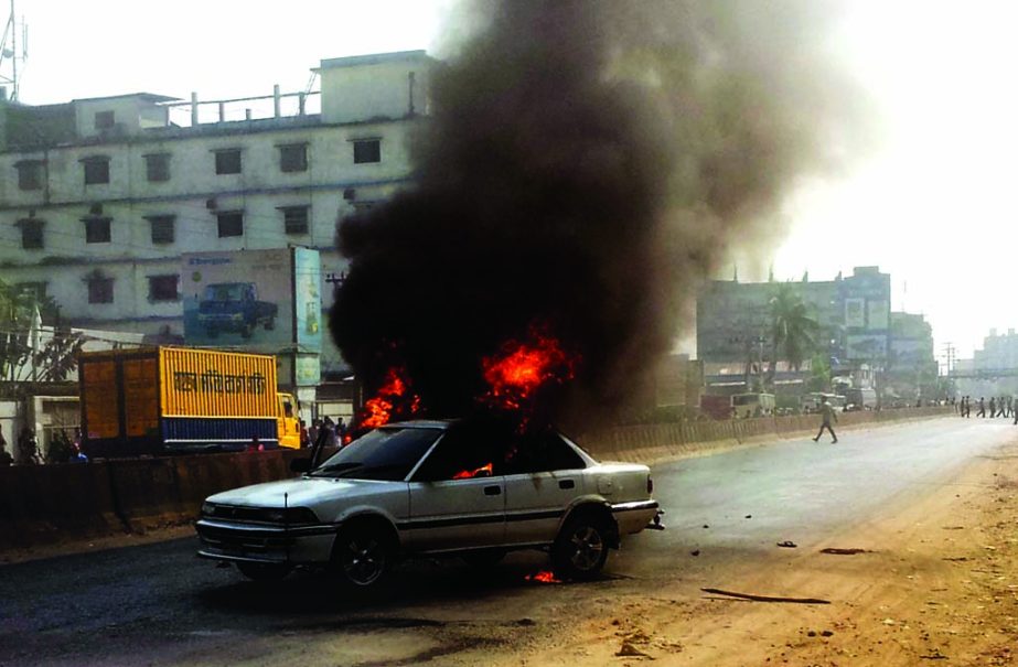 Pro-hartal Jamaat-Shibir pickets torched a private car protesting upholding Kamaruzzaman's death verdict. This photo was taken from Gazipur area on Wednesday.