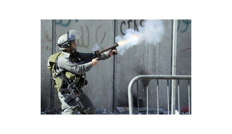 Israeli border policeman shoots tear gas during clashes with Palestinians, as Israeli police limited the access to Al-Aqsa Mosque, in Jerusalem.