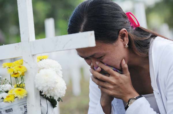 A woman grieves during a memorial ceremony marking the first anniversary of Super Typhoon Haiyan, at a mass grave in the village of Vasper, Tacloban City, central Philippines.