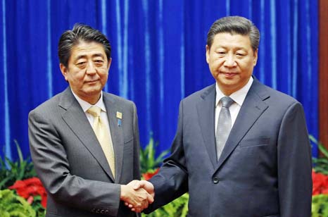 China's President Xi Jinping Â® shakes hands with Japan's Prime Minister Shinzo Abe during their meeting at the Great Hall of the People, on the sidelines of the Asia Pacific Economic Cooperation (APEC) meetings, in Beijing.