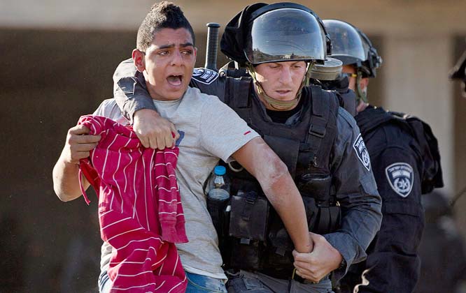 Israeli riot police officers arrests an Israeli Arab protester during a protest of the fatal shooting of a 22-year-old Arab Israeli who was shot dead over the weekend as he appeared to be walking away from a police car, in the Arab village of Kfar Kana, n