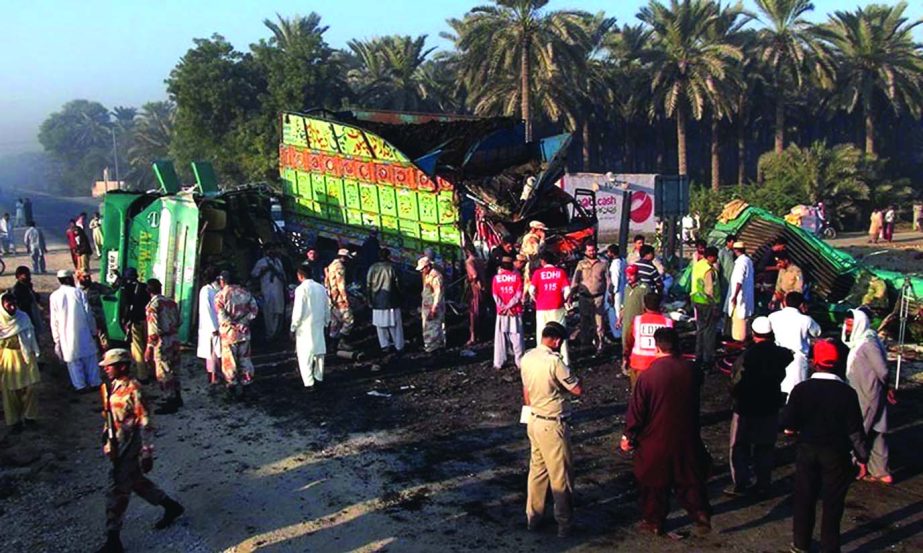Soldiers and rescue workers gether at the site of bus and truck collision in Khairpur district Pakistan on Tuesday.