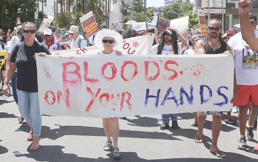 Protesters hold signs and chant as they march through the streets near the Brisbane Convention Center during a demonstration highlighting the fight for justice for Aboriginal deaths in custody ahead of the G-20 summit in Brisbane.