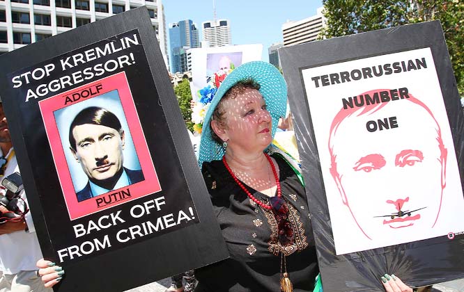 An anti-Russian protester holds placards at a rally during the G-20 in Brisbane, Australia.