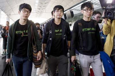Hong Kong Federation of Students leader Alex Chow committee members Nathan Law (L) and Eason Chung react after being refused to board the plane at the Hong Kong International Airport.