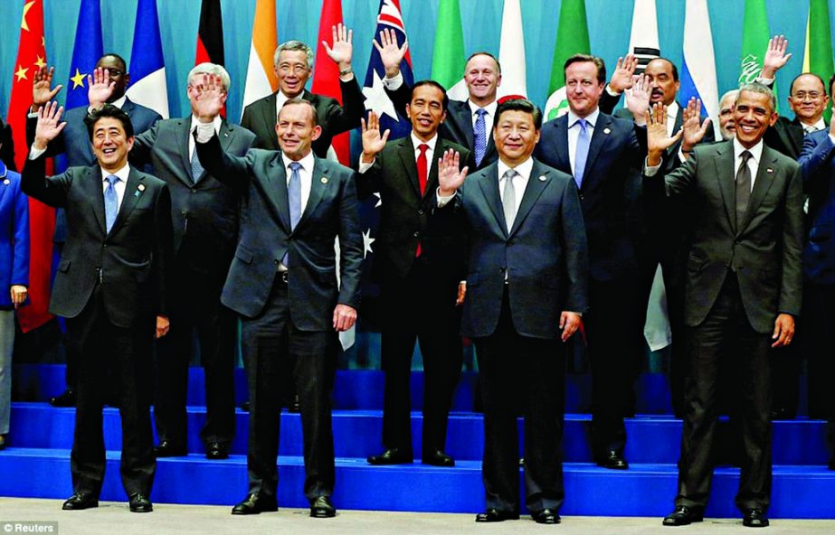 G20 leaders (front row, L-R), Japan's Prime Minister Shinzo Abe, Australian Prime Minister Tony Abbott, China's President Xi Jinping and U.S. President Barack Obama wave during a group photo of G20 leaders and representatives of partner groups at the an