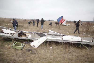 Journalists look at wreckage of Malaysia Airlines Flight MH17 as Dutch investigators inspect the crash site near the Grabove village in eastern Ukraine