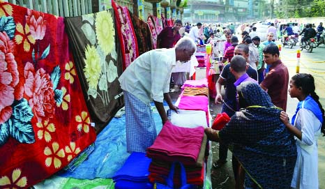 SYLHET: Customers are busy in purchasing various winter clothes including blankets at foot-path markets in Sylhet. This picture was taken from in front of Zilla Parishad office on Monday.