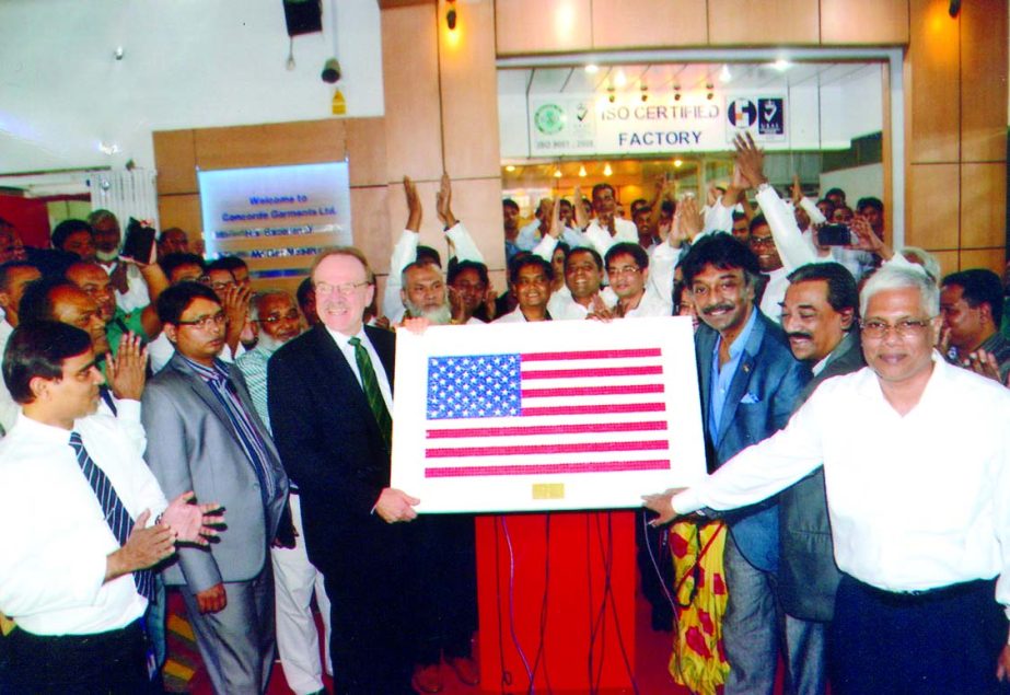 US Ambassador Dan W Mozena receiving a US flag made by buttons from Sayeeful Islam, Managing Director of Concord Garments Ltd as a souvenir at the letter's office on Tuesday.