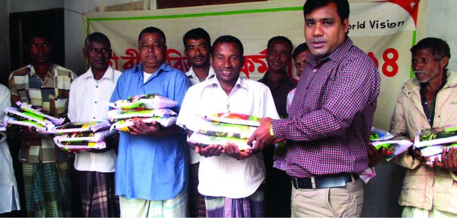 DINAJPUR: Former Chairman of Betdighee Union Ramai Soren distributing maiza seed among the poor farmers at a ceremony as Chief Guest arranged by WVB at Fulbari Upazial on Monday.