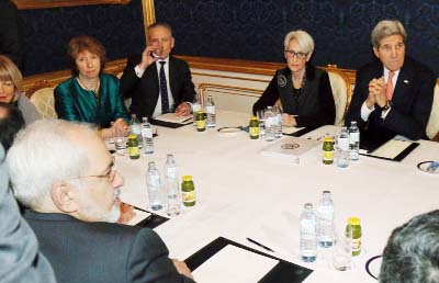 Iranian Foreign Minister Mohammad Javad Zarif, front left, former EU foreign policy chief Catherine Ashton, rear second left, and U.S. Secretary of State John Kerry, right, wait for the start of closed-door nuclear talks on Iran in Vienna, Austria on Frid