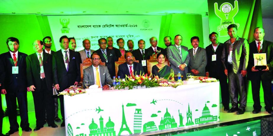 Remitters and investors in bonds pose with Shitangshu Kumar Sur Chowdhury, Deputy Governor of Bangladesh Bank at a "Bangladesh Bank Remittance Award-2013" ceremony in a city hotel on Sunday.