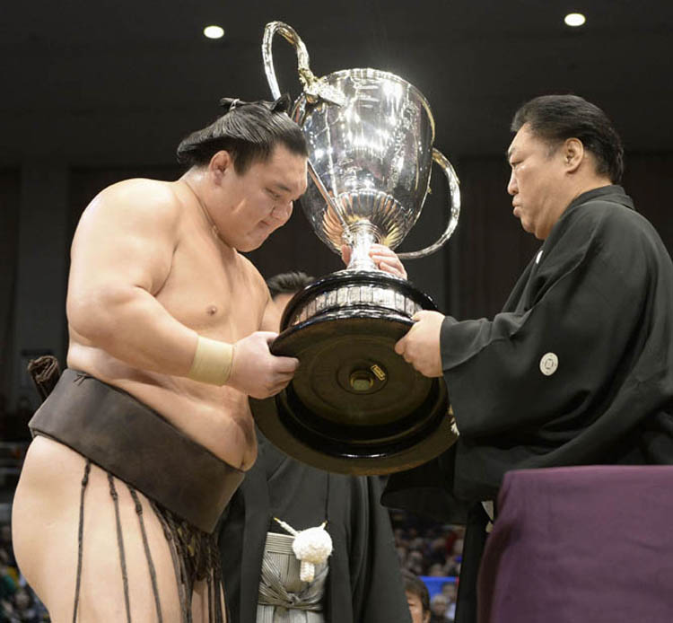 Mongolian grand champion Hakuho (left) receives the trophy from Kitanoumi, chairman of the Japan Sumo Association on the final day of the Kyushu Grand Sumo Tournament in Fukuoka, southern Japan on Sunday. Hakuho beat compatriot Kakuryu at the tournament o